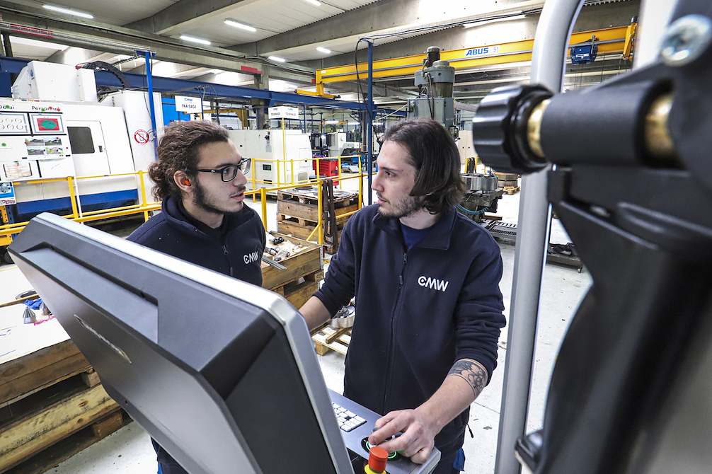 Photo de 2 compagnons en discussion sur une machine outil